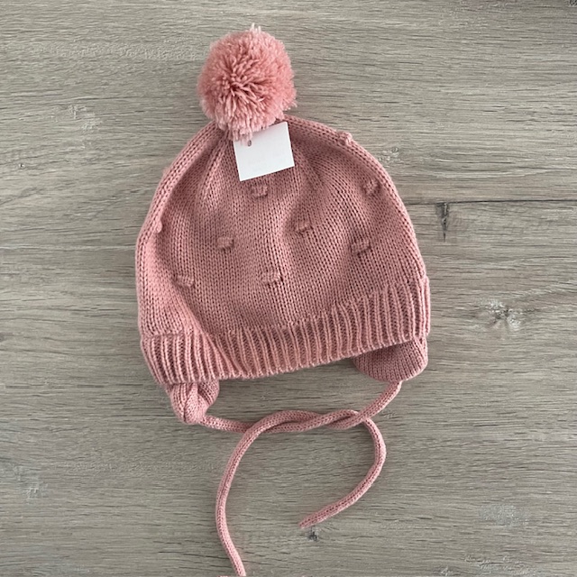 Roze gevoerde muts met pompon en oorflappen